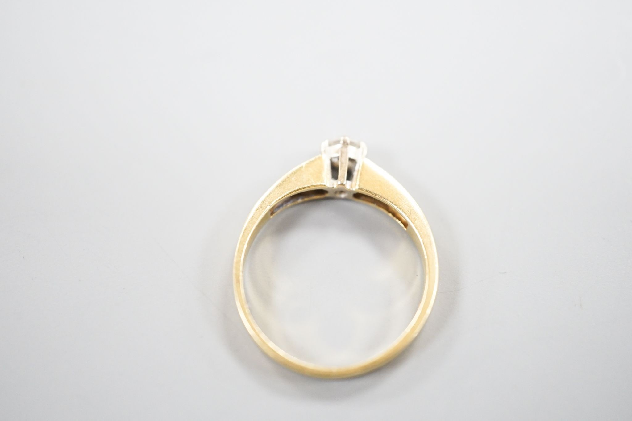 A modern 18ct gold and single stone diamond ring, with diamond set shoulders, size L, gross 2.4 grams.